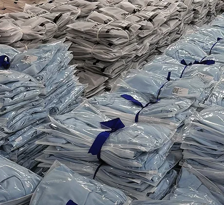 Stacks of poly-bagged garments tied with straps, filling the frame